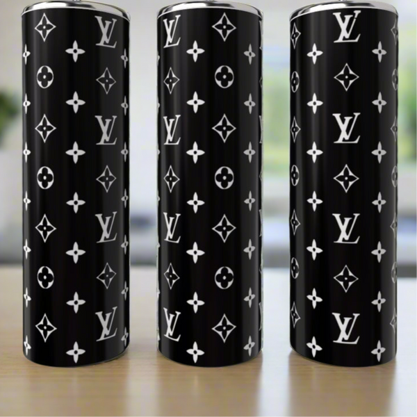 Three Black & White LV 20oz Tumblers by Kreative Kreationz, crafted from high-quality stainless steel with a glossy black finish and repeating white monogram, exude luxury as they sit on a wooden surface.