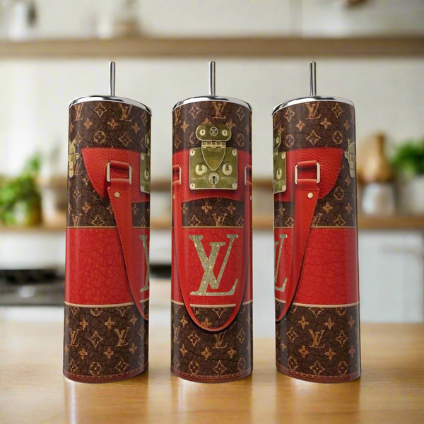 Three LV Red | Brown 20oz Tumblers by Kreative Kreationz, styled with brown and red tones, gold buckle accents, and red faux leather strap prints, are displayed on a kitchen counter for a touch of luxury drinkware.
