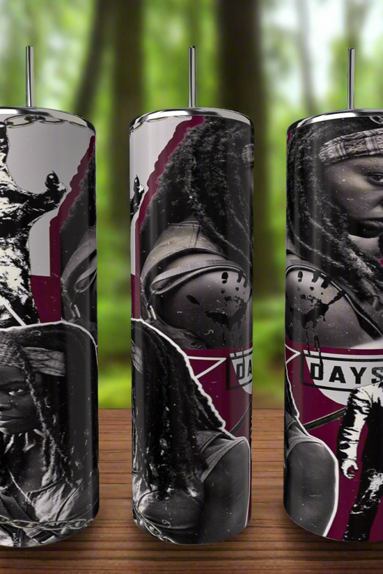 Three cylindrical candles feature black and white images of a person holding a sword against a maroon backdrop, echoing The Walking Dead Tumbler series. They rest on a wooden surface with a blurred forest background. Product: The Walking Dead | Michone | 20oz Skinny Tumbler by Kreative Kreationz.