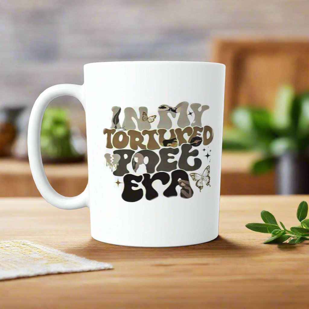 The Kreative Kreationz IN MY TTPD ERA Ceramic Mug features a wavy-font design with butterflies and birds—an ideal gift for any Swiftie or Taylor Swift fan. Perfect as a coffee mug or tea cup from the TTPD collection!.