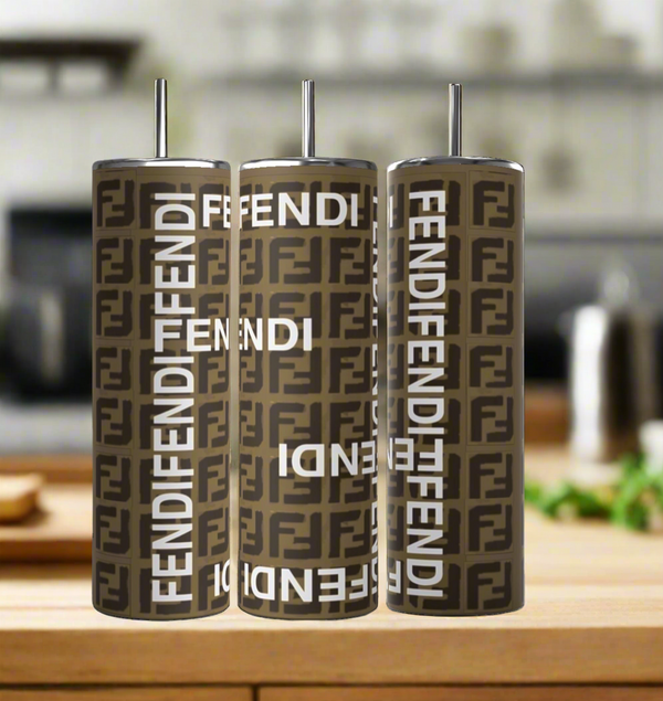 The trio of FENDI Brown 20oz Skinny Tumblers by Kreative Kreationz, featuring straw lids and the brown and black logo with "Fendi" in white, shine against a kitchen scene. These eco-friendly tumblers fuse luxury with sustainability for the style-savvy.
