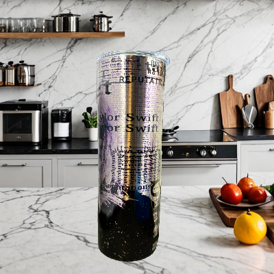 A rolled-up poster is on a marble counter next to the REP Stainless Steel 20oz Tumbler by Kreative Kreationz. An oven and a cutting board with tomatoes and lemons add color in the background, while the poster's text and design are obscured in this kitchen scene.