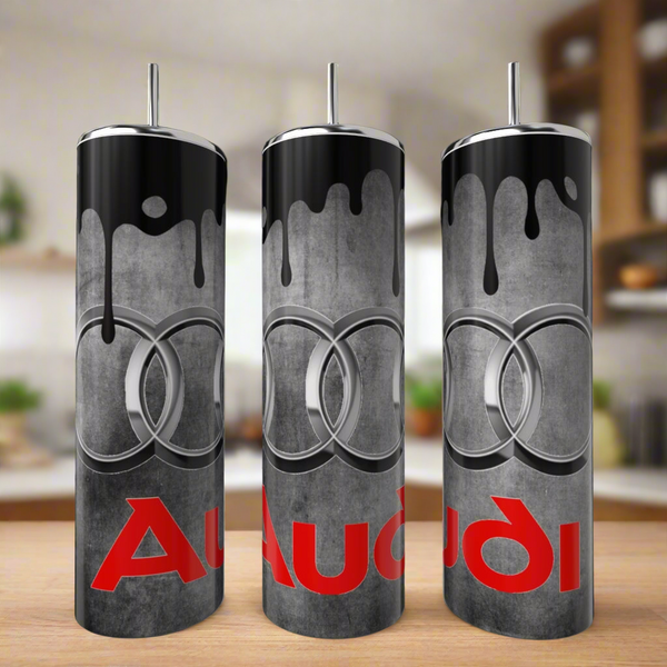 Three Kreative Kreationz Audi Enthusiast Stainless Steel 20oz Tumblers, featuring a black paint drip design with the Audi logo and red "Audi" text, are displayed on wood—an ideal gift for any car lover.