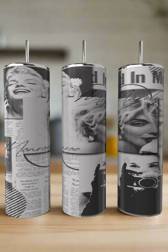 Three Kreative Kreationz Marilyn Monroe 20oz Skinny Tumblers with straws stand on a wooden surface, each displaying black-and-white images, newspaper clippings, and cursive text, glowing against a softly blurred background.