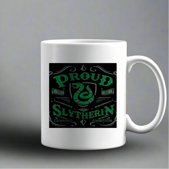 The Kreative Kreationz Proud Slytherin Ceramic Mug is a white mug with a green and black snake design and the text 