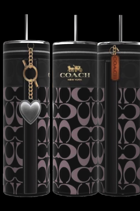 A trio of Coach Heart Designed 20oz Tumblers from Kreative Kreationz, each featuring a cylindrical shape with a black and gray Coach pattern. These tumblers have contrasting black stripes and are adorned with different charms: a silver heart, a gold Coach logo, and a brown tag inscribed with 