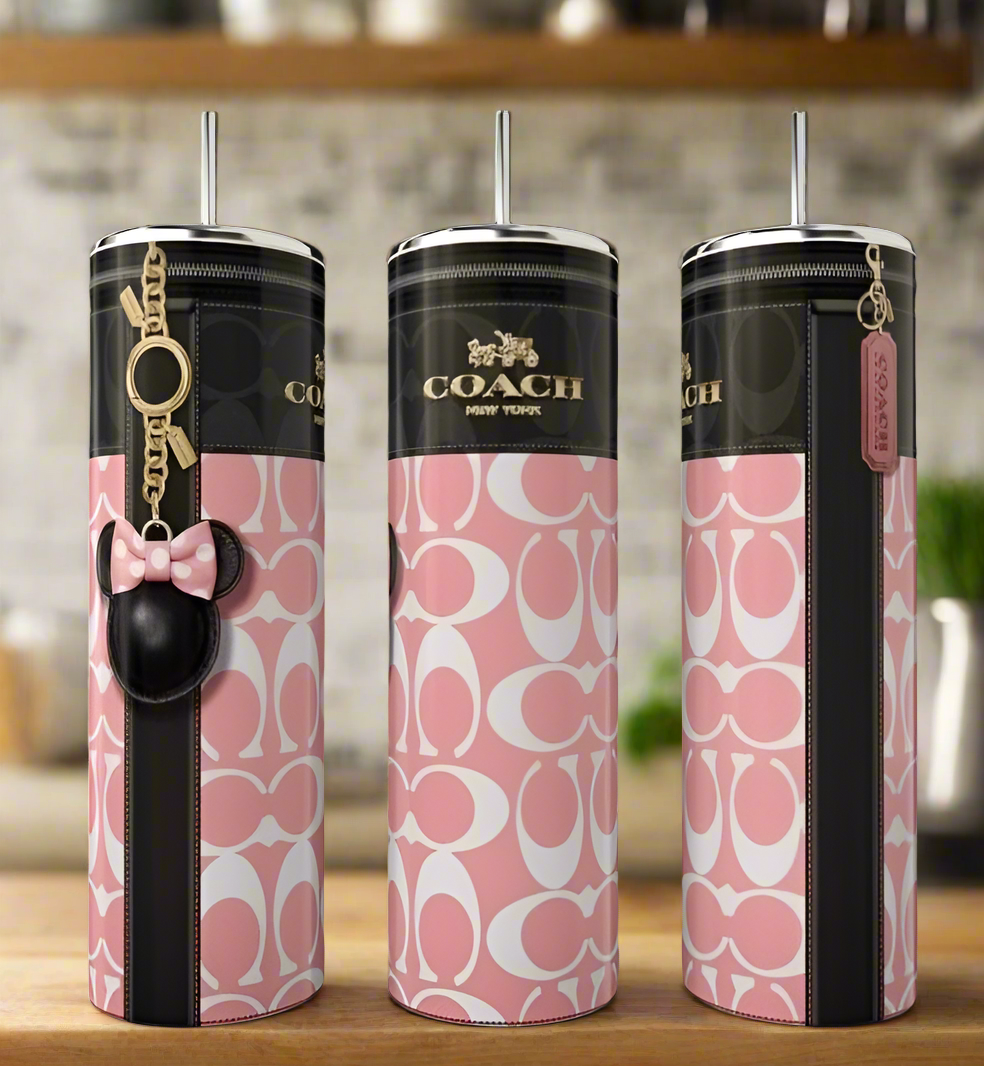 Three Kreative Kreationz Coach Pink Minnie 20oz Skinny Tumblers with pink and white logo patterns, black accents, straw lids, and keychains sit on a kitchen counter—stylish luxury drinkware for any setting.