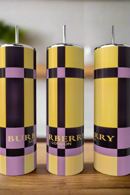 Three tall, cylindrical Kreative Kreationz Burberry 20oz Skinny Tumblers with metal straws sit on a wooden surface. The stainless steel set features yellow, black, and lavender checks with 