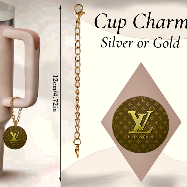 The Louis Vuitton Charm Dangle from Kreative Kreationz features a tumbler charm on a mug handle, with a 12cm/4.72in gold chain and patterned round pendant. This handcrafted accessory is available in silver or gold.