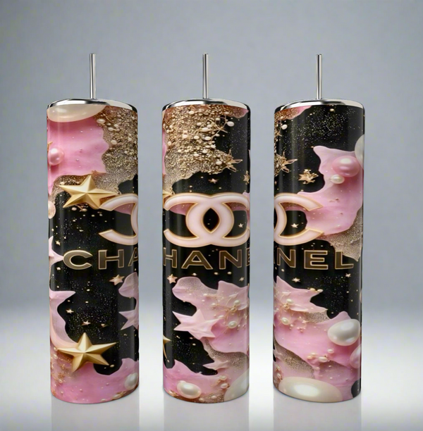 The Chanel 20oz Skinny Tumbler by Kreative Kreationz features three tall, glossy tumblers with metallic rods, pink and gold stars and Chanel logos, set against a black background—showcasing luxury stainless steel drinkware artistry.