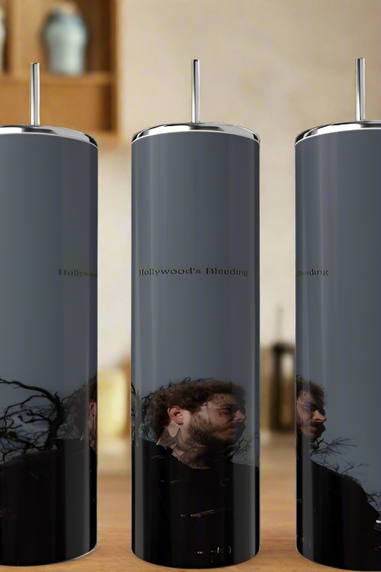 Three tall, luxury Posty Tumblers by Kreative Kreationz sit on a kitchen countertop reflecting an outside scene. Each dark gray tumbler with a metallic lid shows part of a man's face, trees, and sky. Blurred kitchen items linger in the background.
