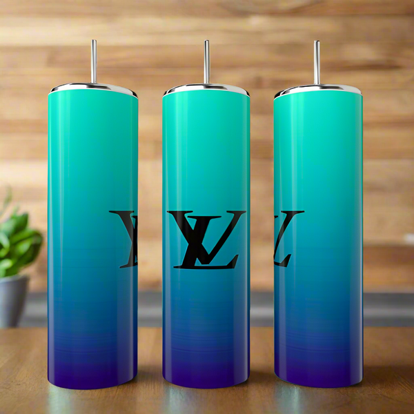 Three Ombré LV 20oz Tumblers by Kreative Kreationz in blue and green hues with metal straws rest on wood. Featuring a luxe "LV" logo, they’re an eco-friendly, reusable pick—perfect next to a blurred potted plant in the background.