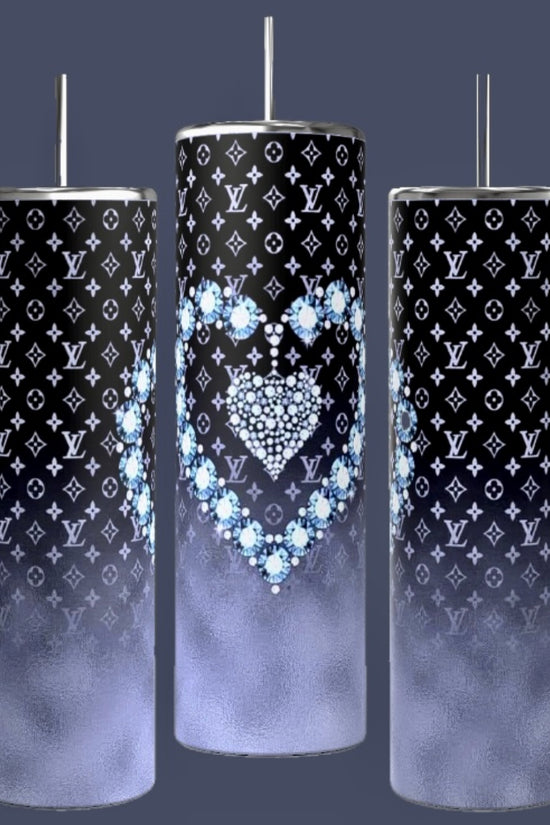 Three LV Designer 20oz Tumblers by Kreative Kreationz feature a tall, cylindrical design with spill-proof metallic lids and straws. They showcase a black and white designer pattern, with the middle tumbler adorned with a heart design crafted from blue flowers. Each tumbler transitions to a gradient foggy gray towards the bottom.