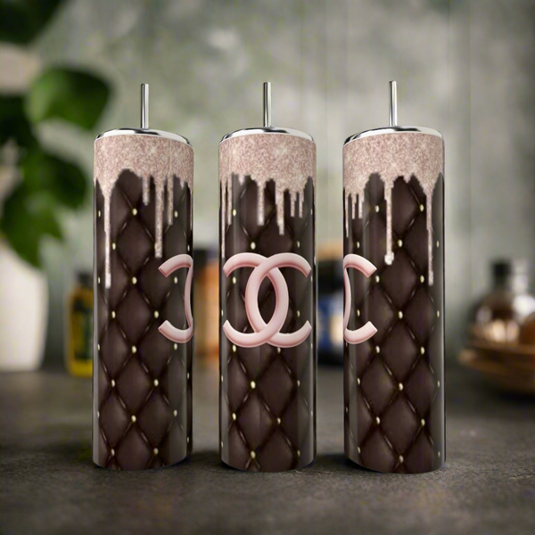 Three Chanel Pink Drip 20oz Tumblers by Kreative Kreationz, featuring quilted brown patterns, shiny silver lids, pink interlocking "C" logos, and dripping chocolate accents, bring luxury drinkware style to your kitchen counter.