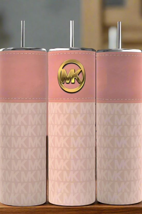 Three Kreative Kreationz stainless steel tumblers, featuring metal lids and straws, sit side-by-side. They have a pink top with a gold Michael Kors logo and a patterned lower section with a repeated MK design, against an elegantly blurred background.