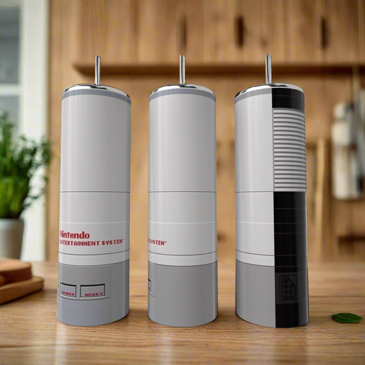 Three Kreative Kreationz Nintendo Collection 20oz Tumblers, styled after classic NES consoles, sit on a wooden counter with blurred kitchen shelves behind—ideal for fans wanting standout, luxury drinkware.