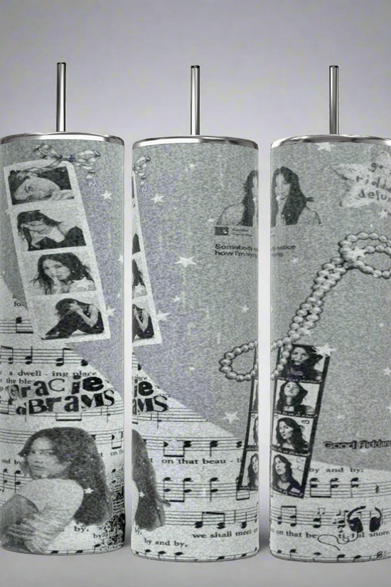 The Kreative Kreationz Gracie Abrams Picture Collage 20oz Skinny Tumbler features a grayscale collage design that includes images of a woman, musical notes, filmstrips, stars, and text elements. These stylish cylindrical tumblers come with reusable straws protruding from the tops.