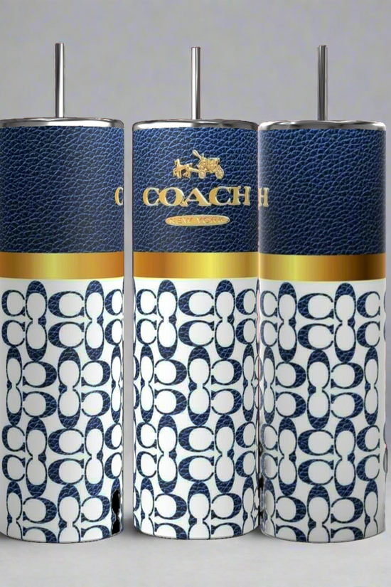 Three Coach-inspired dark blue 20oz tumblers from Kreative Kreationz, each accompanied by a metal straw, are displayed. These tumblers showcase a textured dark blue upper section featuring the 