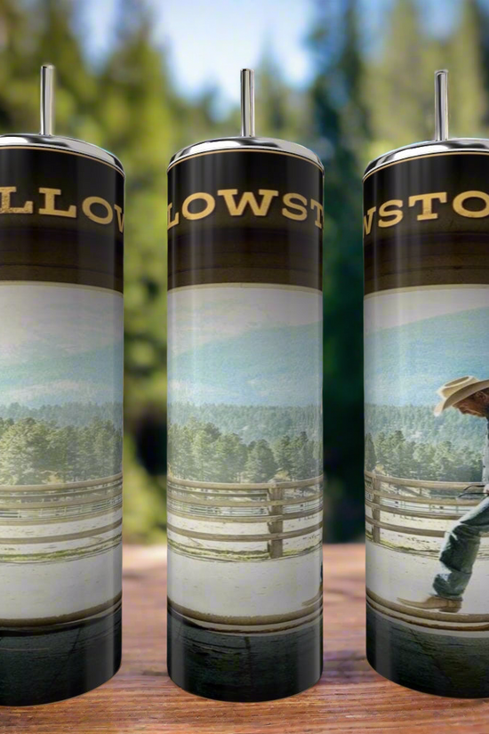 Three Kreative Kreationz John Dutton Yellowstone 20oz tumblers with metal straws are displayed on wood. Each stainless steel tumbler shows a cowboy by a fence with a scenic forest and mountain background.