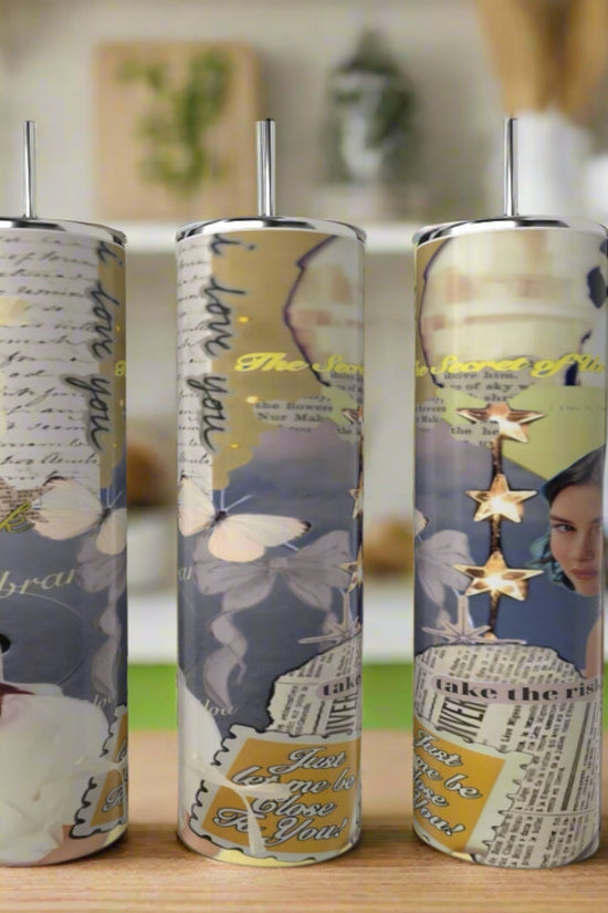 Three tall Gracie Abrams 20oz Skinny Tumblers by Kreative Kreationz, featuring blue collage-style designs with butterflies, handwritten notes, a woman’s face, gold stars, and inspirational text, stand on a kitchen counter.