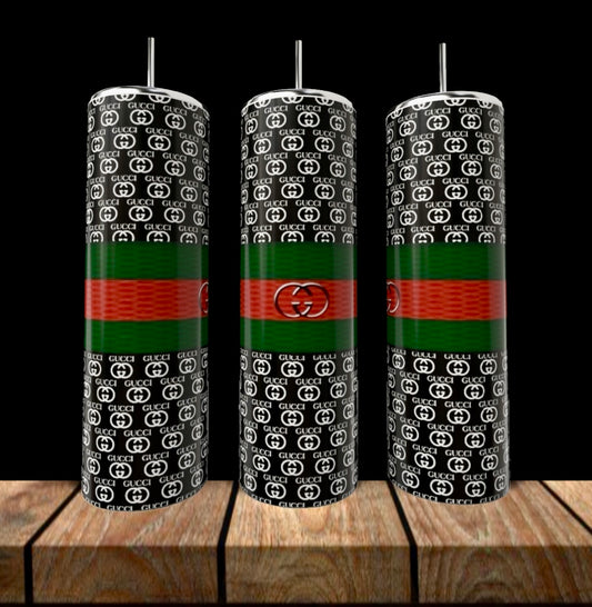Three GUCCI 20oz Skinny Tumblers by Kreative Kreationz with black backgrounds, white "GG" logos, green and red stripes, silver straws, and central circular emblems stand on a wooden surface—stylish luxury drinkware.