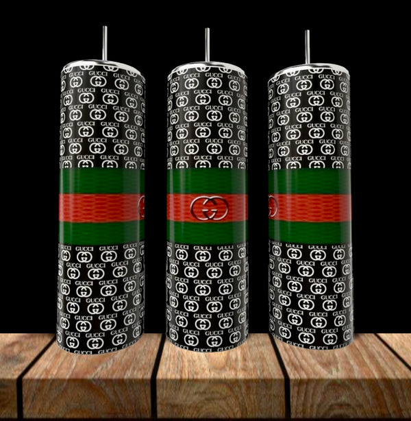 Three GUCCI 20oz Skinny Tumblers by Kreative Kreationz with black backgrounds, white "GG" logos, green and red stripes, silver straws, and central circular emblems stand on a wooden surface—stylish luxury drinkware.