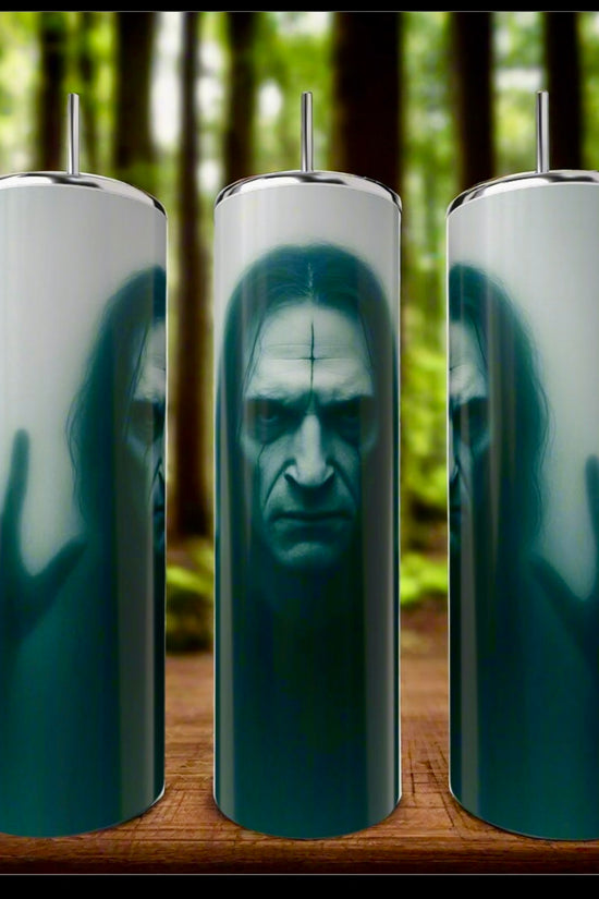 Three The Crow 20oz Tumblers by Kreative Kreationz are pictured against a blurred forest backdrop. Each stainless steel tumbler displays a haunting pale face with dark markings and long hair, seen through misty glass with a hand pressed against it.