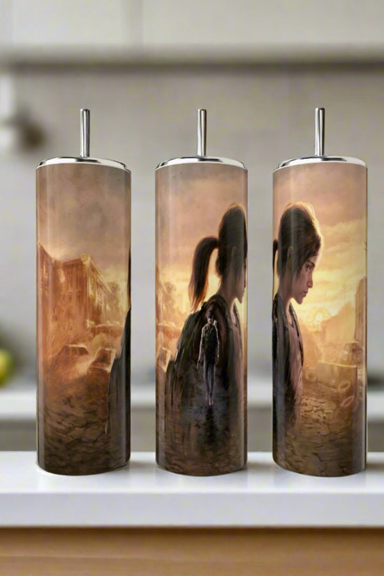 Three Kreative Kreationz 20oz Skinny Tumblers display a sepia-toned, continuous Last Of Us-inspired illustration featuring Ellie with a backpack in a post-apocalyptic city, shown from various angles on a kitchen counter.