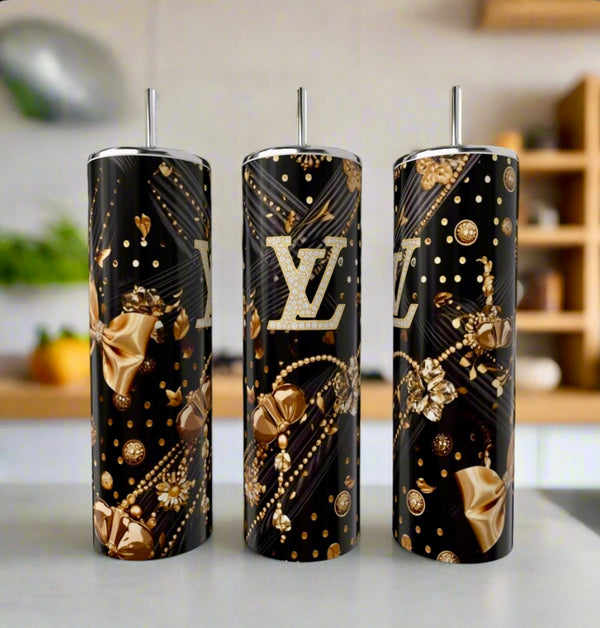 Three Louis Vuitton Black & Gold 20oz Tumblers by Kreative Kreationz, featuring metallic gold floral designs and bold gold "LV" logos, stand on a kitchen counter, exemplifying luxury drinkware.