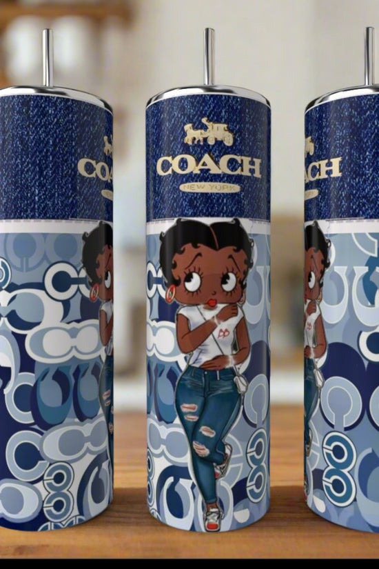The Betty Boop 20oz Tumbler by Kreative Kreationz features a cartoon woman in jeans and a white top on a blue and white patterned background, silver straw, 