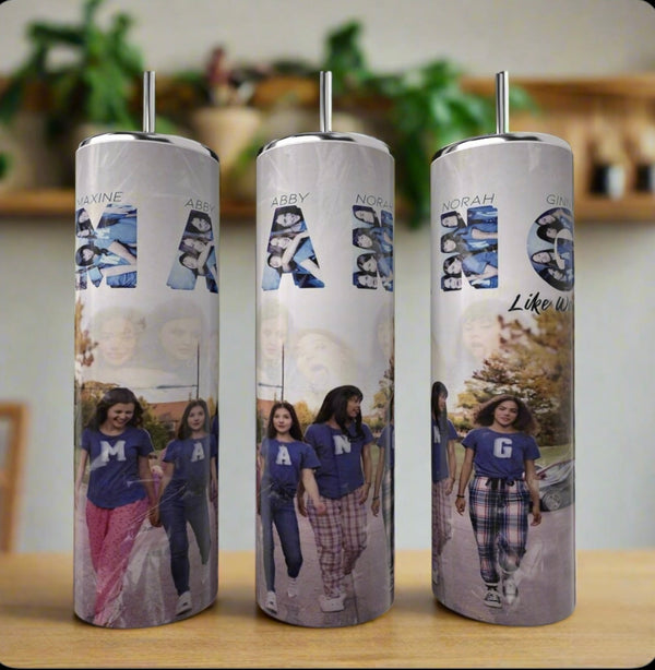 The Kreative Kreationz Ginny & Georgia MANG Girls 20oz Tumbler showcases a collage of four girls in "M", "A", "N", and "G" shirts against a blurred backdrop, blending eco-friendly luxury with personalized style.