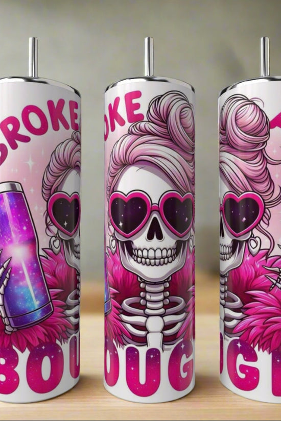 The Kinda Boujee But Broke 20oz Tumbler by Kreative Kreationz features a cartoon skeleton with pink sunglasses and a fur coat holding a sparkly cup, plus bold 
