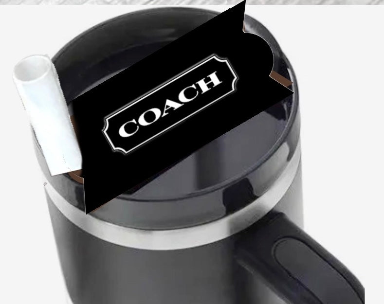 A black mug by Kreative Kreationz, viewed from above, holds a white rolled paper and a Coach | Stanley Lid Plate/Topper with a Coach-branded black card inside.