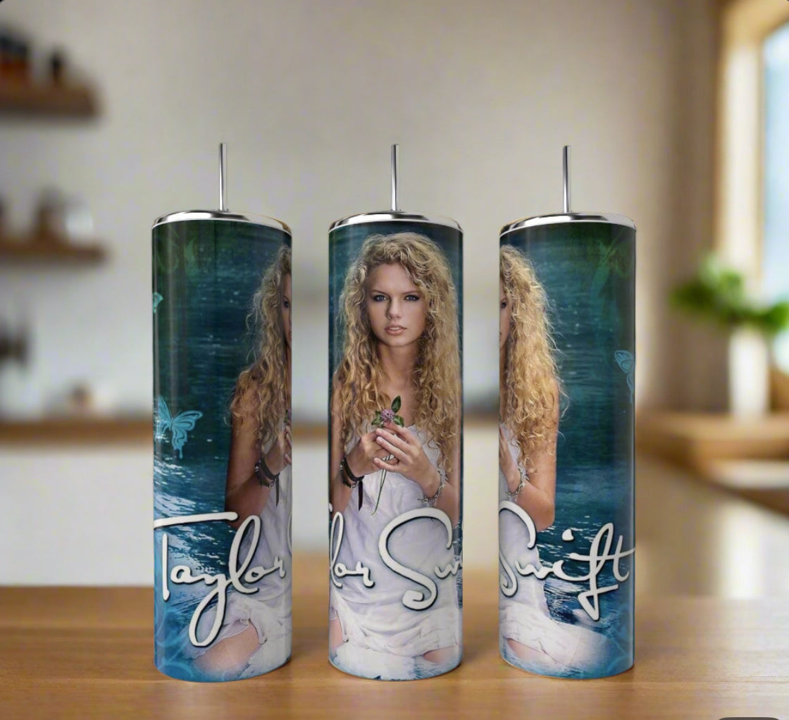 The Taylor Swift Debut 20oz Tumblers by Kreative Kreationz feature eco-friendly stainless steel with a luxury design of Taylor Swift in a white dress, long curly blonde hair, and greenery by water. Reusable and stylish—set of three.