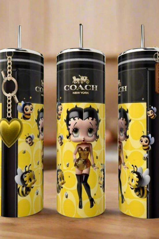 Three tall Kreative Kreationz Betty Boop | Yellow 20oz Tumblers feature cartoon Betty Boop with a bee, surrounded by bees, honeycomb patterns, and a yellow heart keychain—a stylish luxury-inspired addition to any kitchen.