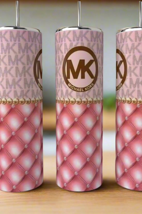 Three tall Kreative Kreationz MK Pink|Gold 20oz tumblers with straws, featuring a pink quilted design, pearl accents, and the iconic MK logo, are displayed on a wooden surface for a touch of luxury drinkware style.