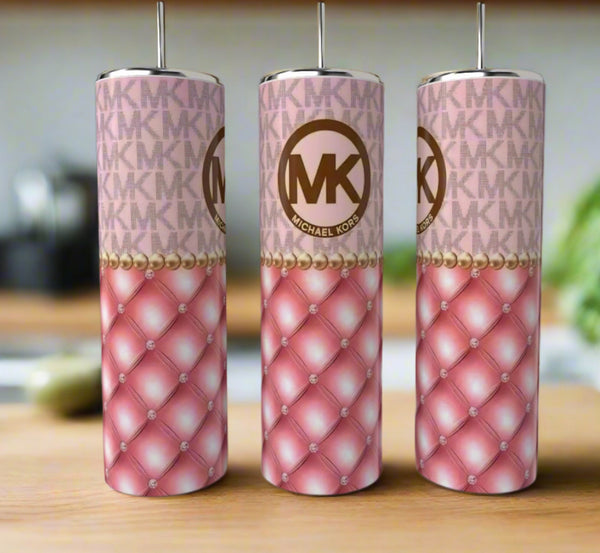 Three tall Kreative Kreationz MK Pink|Gold 20oz tumblers with straws, featuring a pink quilted design, pearl accents, and the iconic MK logo, are displayed on a wooden surface for a touch of luxury drinkware style.
