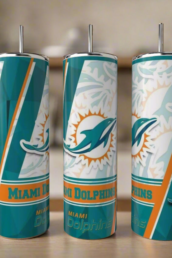 Three Kreative Kreationz Miami Dolphins 20oz Skinny Tumblers, made of durable stainless steel and featuring the team logo in teal, orange, and white, stand together on a kitchen counter—an ideal reusable set for fans.