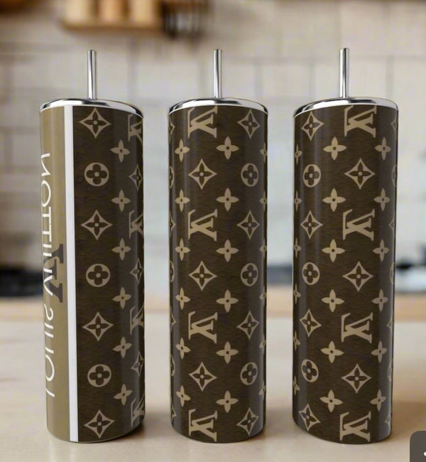 Three Kreative Kreationz LV Brown 20oz Tumblers with silver lids and straws sit on a kitchen counter, each featuring a brown and beige monogram—an elegant upgrade for your luxury drinkware collection.