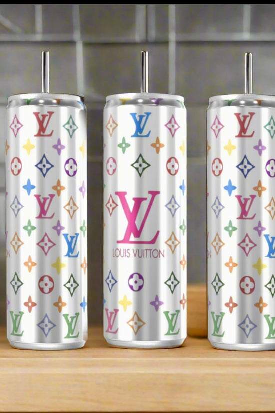 Three LV Multicolor Silver Stainless Steel Inspired 20oz Tumblers by Kreative Kreationz sit on a kitchen counter, their vibrant logos and sleek design contrasting with the blurred vegetables and utensils in the background.