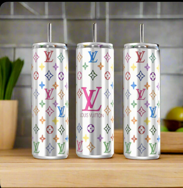 Three LV Multicolor Silver Stainless Steel Inspired 20oz Tumblers by Kreative Kreationz sit on a kitchen counter, their vibrant logos and sleek design contrasting with the blurred vegetables and utensils in the background.