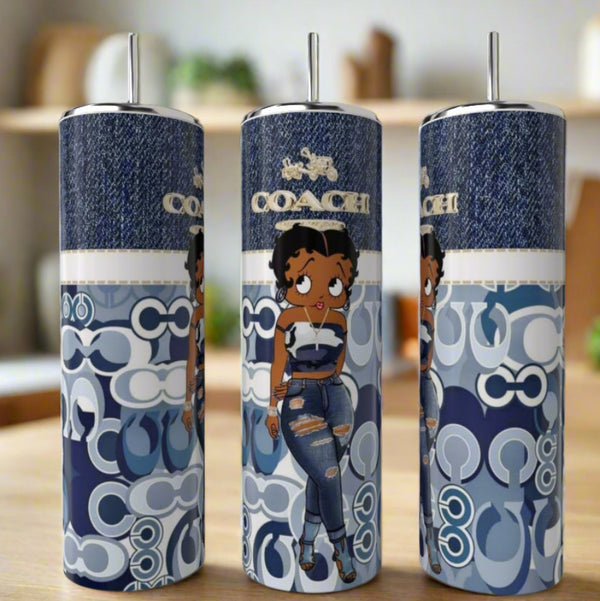 Three eco-friendly Betty B Blue Coach 20oz Skinny Tumblers by Kreative Kreationz, each with a cartoon woman in blue and Coach logo patterns over denim textures, are displayed on a wooden table.