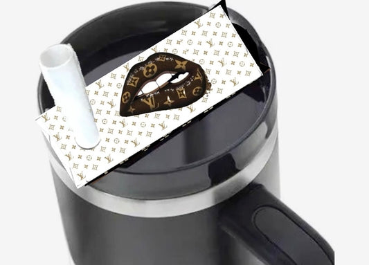 The Louis Vuitton Drip Lips Stanley Lid Plate/Topper by Kreative Kreationz decorates a black mug with a handle, featuring stylized lips and LV-inspired patterns. A white straw extends from the lid.