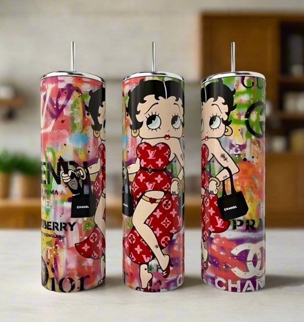 The Betty Boop Diva 20oz Tumbler by Kreative Kreationz features three tall stainless steel tumblers with colorful graffiti backgrounds, showing Betty Boop in red and luxury-inspired designs with iconic brand logos.