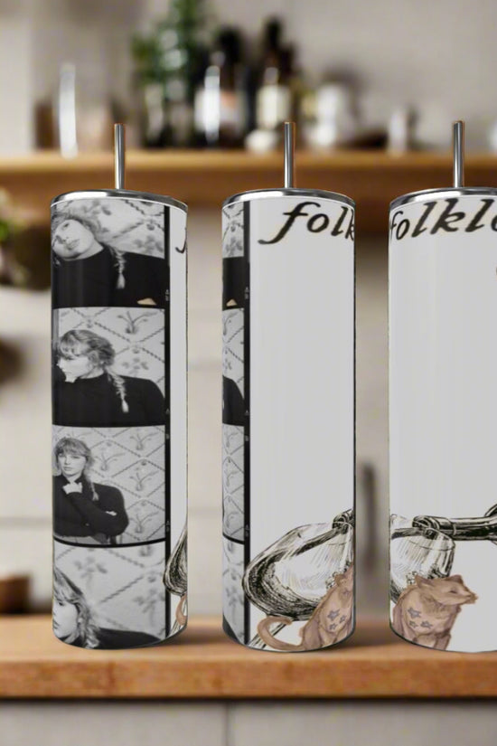 Three Kreative Kreationz Folklore Polaroid Taylor Swift 20oz Skinny Tumblers with straws sit on the counter, each featuring black-and-white Folklore photos, 