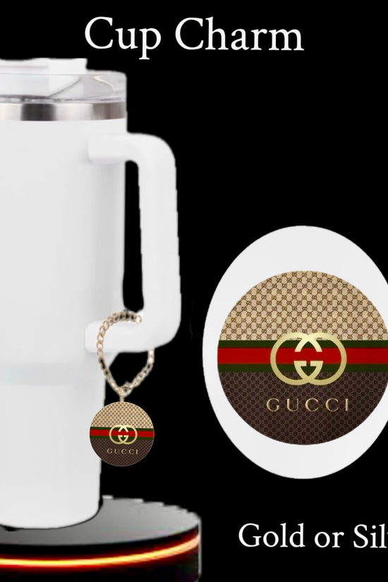 The Gucci Charm Dangle | Cup Accessory by Kreative Kreationz is a round gold and brown tumbler charm with red and green stripes, Gucci logo, and waterproof design. Available in gold or silver. Text reads 