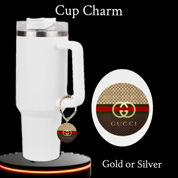 The Gucci Charm Dangle | Cup Accessory by Kreative Kreationz is a round gold and brown tumbler charm with red and green stripes, Gucci logo, and waterproof design. Available in gold or silver. Text reads "Cup Charm.