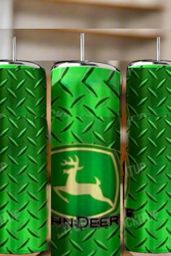 Three green John Deere 20oz Skinny Tumblers by Kreative Kreationz, featuring a double-walled design, metal diamond plate pattern, and leaping deer logo, are displayed on a wooden surface with a blurred indoor background.