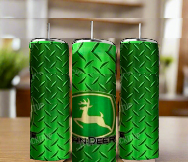Three green John Deere 20oz Skinny Tumblers by Kreative Kreationz, featuring a double-walled design, metal diamond plate pattern, and leaping deer logo, are displayed on a wooden surface with a blurred indoor background.