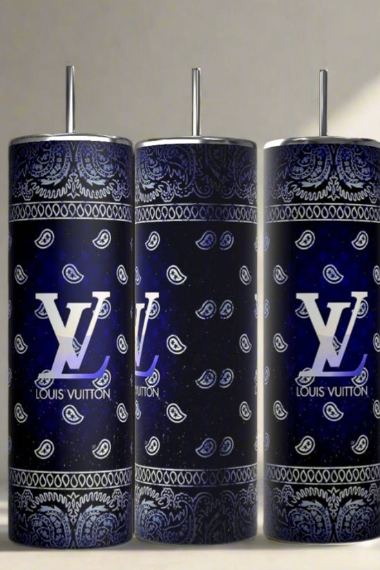 Three Louis Vuitton Blue Ombre 20oz Tumblers by Kreative Kreationz, each with a metal straw and decorated in a blue and black paisley bandana pattern with large white logos, are displayed on a light surface next to a small green plant.